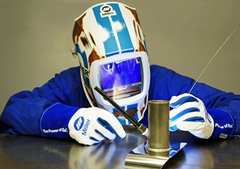 TIG weld technique close up with relic helmet in background