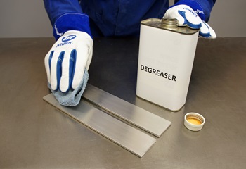 Welder degreasing base metal to prep for TIG welding